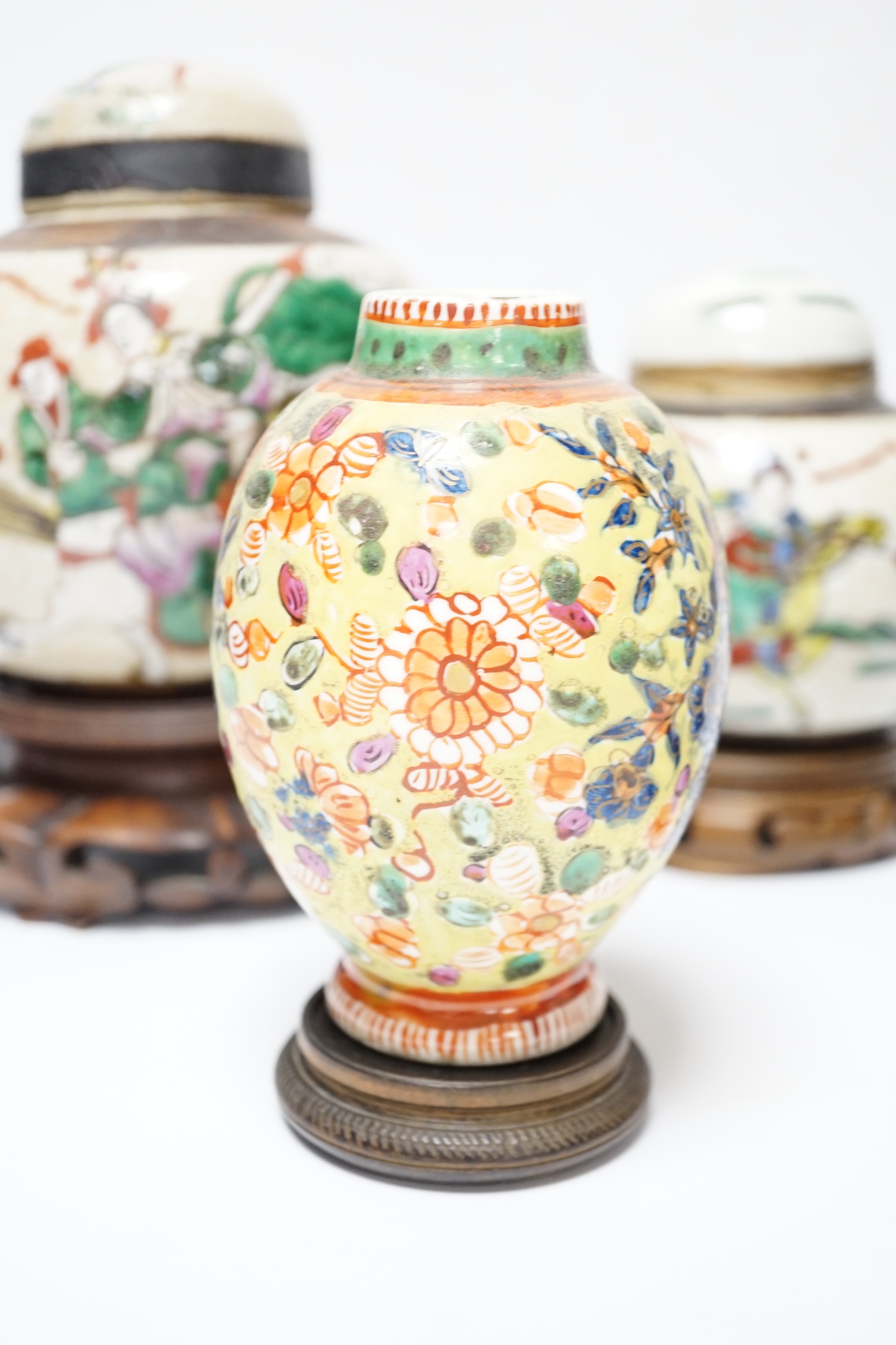 A Chinese famille verte vase, Kangxi period (cut down) and three Chinese polychrome jars with hardwood stands, tallest 19cm